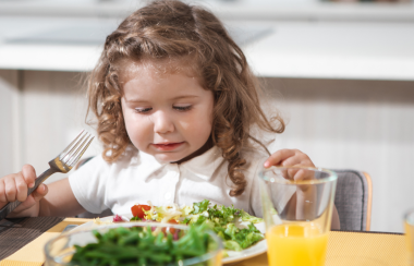 Una niña comiendo ensalada