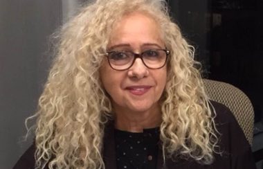 Évelyne Abitbol vêtue d'un chandail noir.